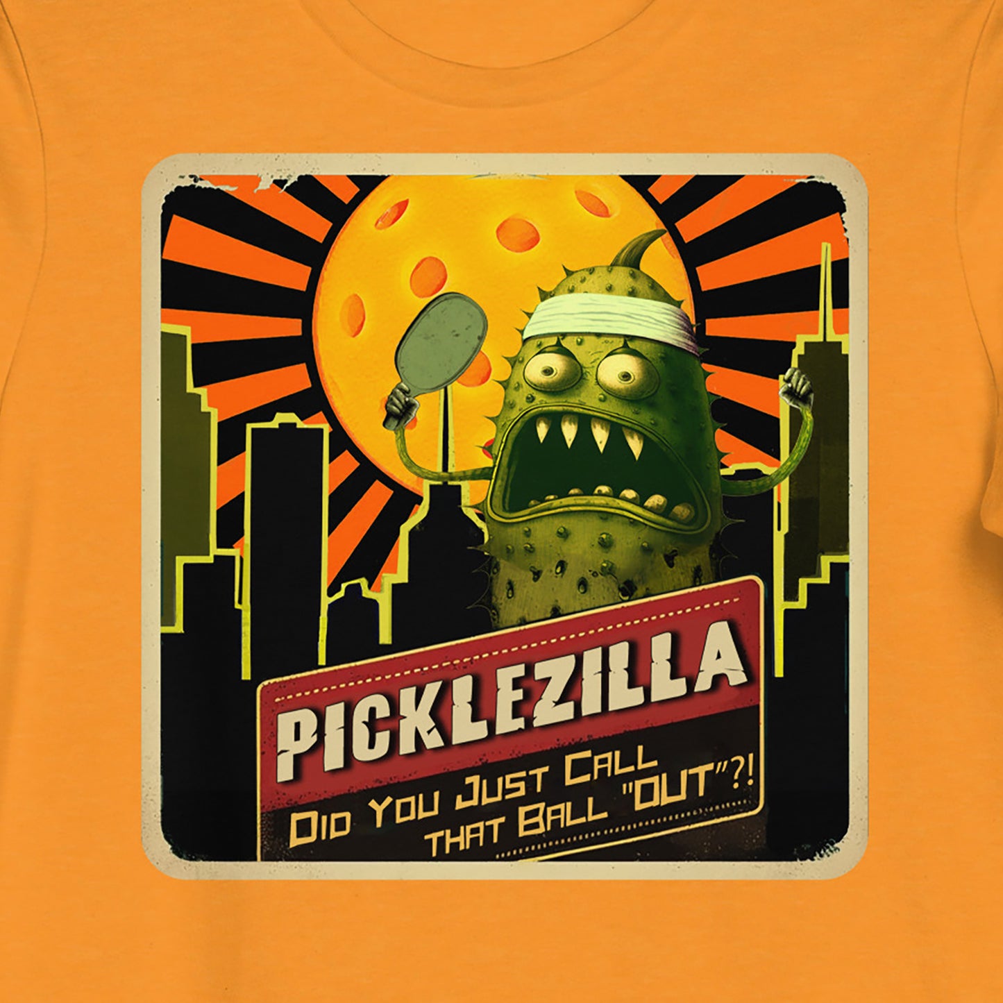 Closeup view of Picklezilla Out Call graphic on front of Orange short-sleeve Women's pickleball shirt