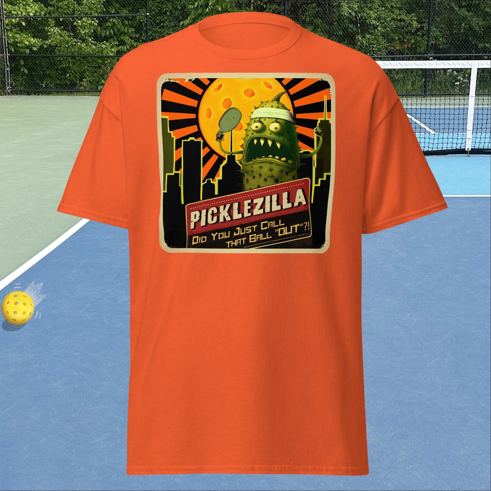 Orange short-sleeve Men's pickleball shirt with Picklezilla Out call graphic on front